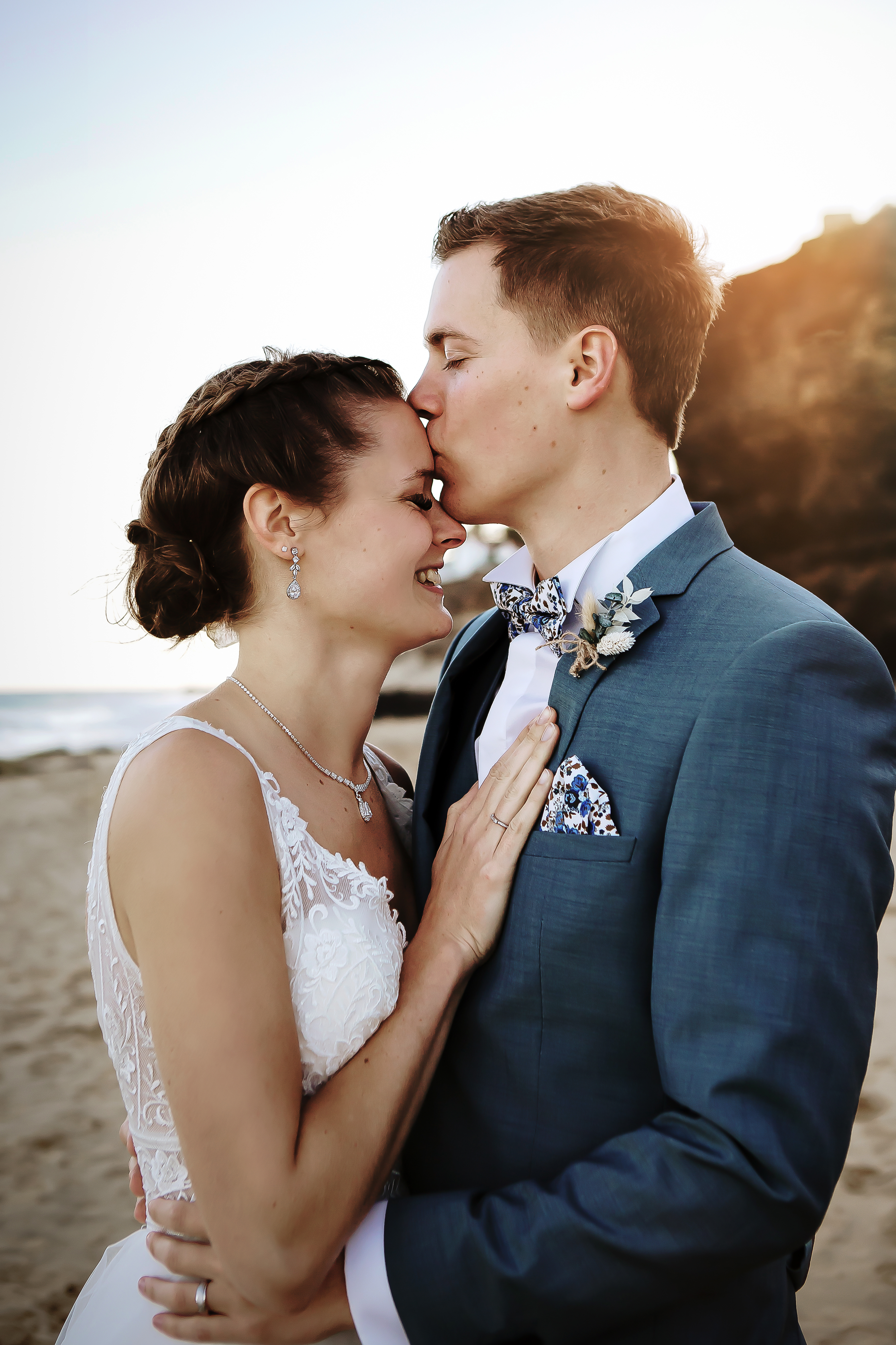 Groom passionately kiss the forhead of the bride in the beach of Fuerteventura